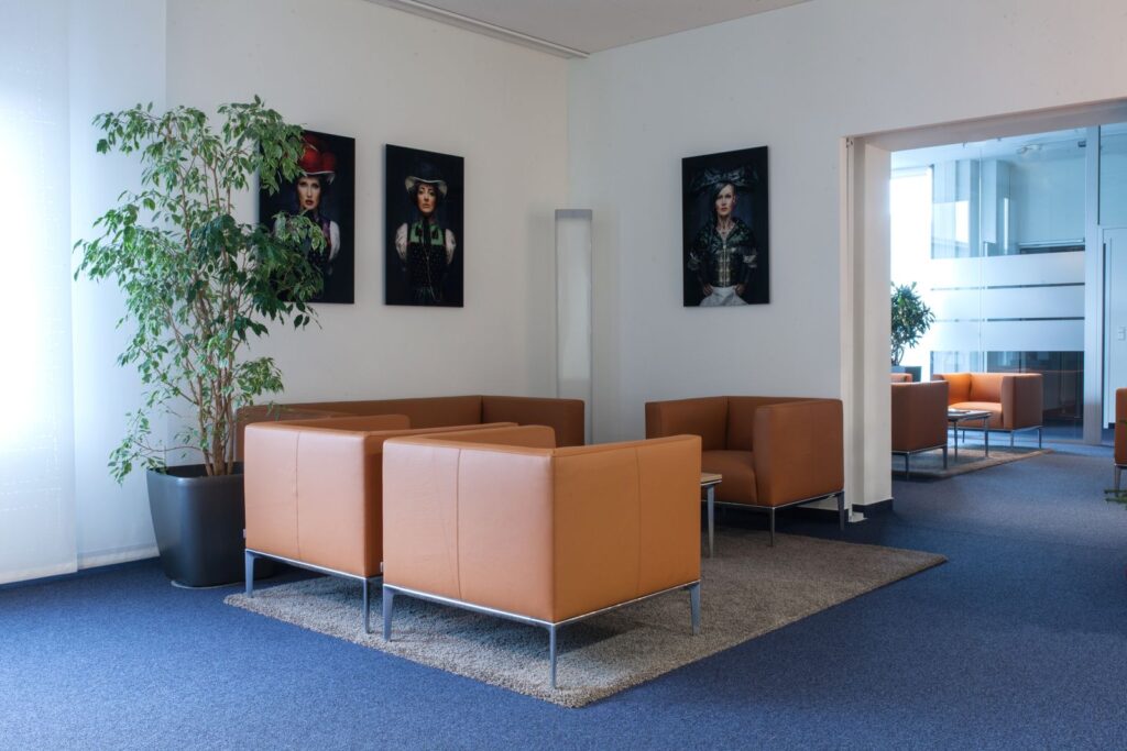 Empfangsbereich mit Sesseln und Bildern an der Wand